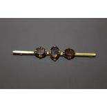 A 9CT GOLD TIE PIN WITH THREE SMOKY QUARTZ STONES