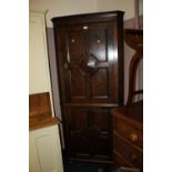 A 1920S JACOBEAN STYLE OAK FLOORSTANDING CORNER CUPBOARD