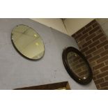 AN OAK FRAMED OVAL MIRROR TOGETHER WITH ANOTHER