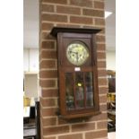 AN OAK CASED WALL CLOCK