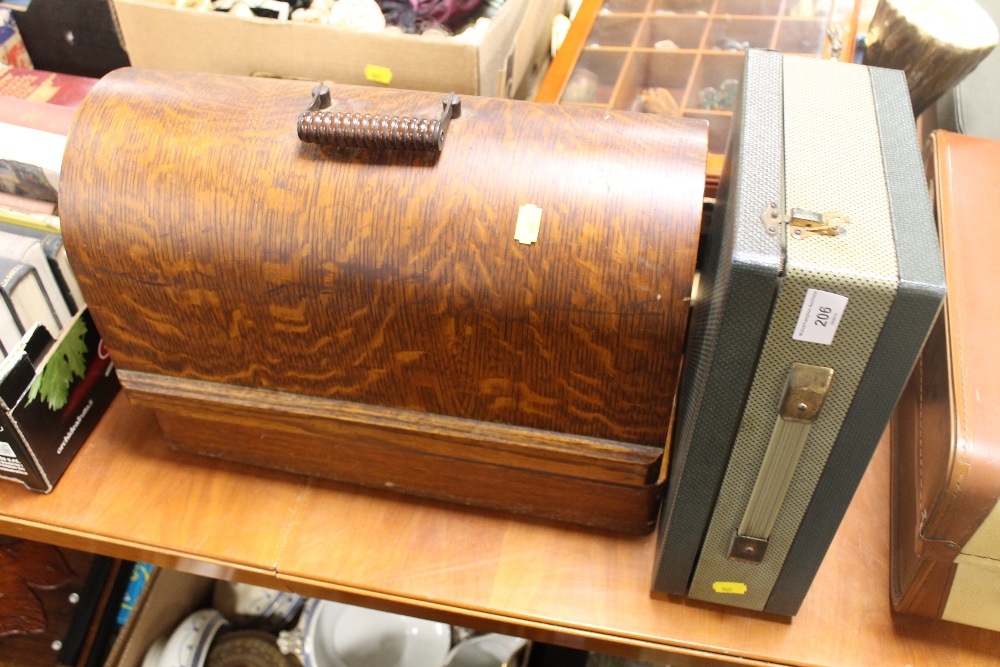 A CASED SINGER SEWING MACHINE TOGETHER WITH A VIDOR RADIO