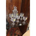 A CUT GLASS DECANTER AND FIVE DRINKING GLASSES