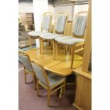 A LIGHT OAK EXTENDING DINING ROOM TABLE AND EIGHT CHAIRS