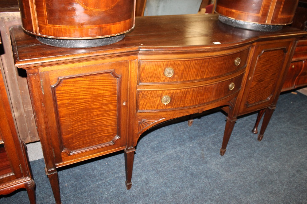 A LARGE BOW FRONTED MAHOGANY SIDEBOARD RAISED ON EIGHT LEGS WITH CARVED DETAILS