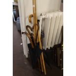 A COLLECTION OF WALKING STICKS, POOL CUES, ETC