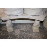 A STONE CURVED SEAT ON SQUIRREL PLINTHS