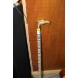 A MOTHER OF PEARL INLAID WALKING CANE WITH EAGLE HEAD HANDLE