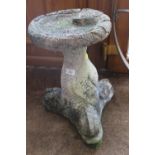 A CARVED STONE BIRD BATH WITH SCALED BASE