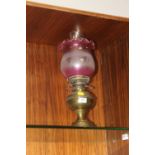 A BRASS OIL LAMP WITH PINK & WHITE FROSTED SHADE