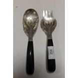 AN EASTERN WHITE METAL PIERCED FORK & SPOON SET WITH DRAGON EDGED DETAIL