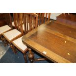 AN OAK DRAWLEAF DINING TABLE WITH SIX CHAIRS