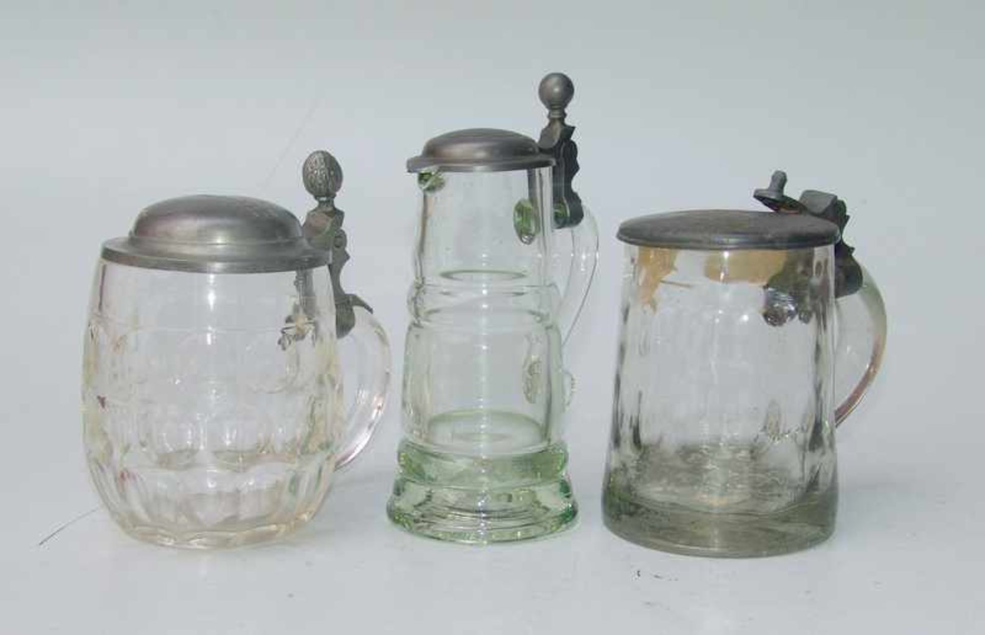 3 Deckelkrüge, um 1900 farbloses Glas mit Zinnmontierung, verschieden Formen und Größen, Höhe 14cm-