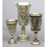 Drei Kiddusch-Fußbecher. 800/000 Silber, 358 g. Glockenförmige Kuppa und Fuß mit Reliefdekor bzw.