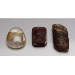 Drei ungefasste Edelsteine: Turmalingravur in Blattform, 18,43 ct.; ovales Bergkristallcabochon
