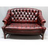 Chesterfield-Sofa, Zweisitzer. Weinrote Lederpolsterung mit Knöpfung, Mahagonirahmen.