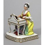 Skulptur "Dame am Spinett", Meissen. Elegant gekleidet, auf Rechtecksockel. Bunt bemalt,