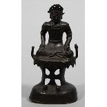 Guanyin. Bronze mit schwärzlicher Patina. Auf hohem, durchbrochen gearbeiteten Felsensockel sitzende