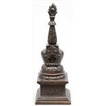 Stupa. Zweiteiliger Guss aus patinierter Bronze. Auf quadratischer, gestufter Grundfläche gebauchter