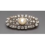 Art Deco-Brosche. 14 kt. GG und WG, geprüft, brutto 9 g. Oval durchbrochen gearbeitet, mittig mit