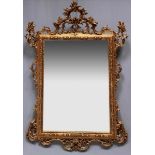 Großer Prunk-Spiegel im Rokokostil. Stuck, vergoldet. Facettierter Spiegeleinsatz. 157x 110 cm.