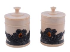 A pair of ivory cylindrical boxes,   circa 1900, with turned finials to the flat pull-off cover,