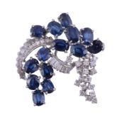A sapphire and diamond abstract brooch,   circa 1970, the scrolled brooch set with oval shaped