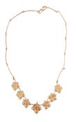 A vine leaf necklace,   the seven leaf shaped panels, two with brilliant cut diamond accents to a