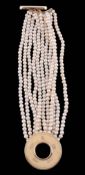 A cultured pearl bracelet,    the eleven strands composed of uniform cultured pearls, to a circular