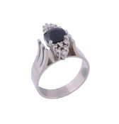 A sapphire and diamond dress ring,   the circular shaped sapphire claw set between clusters of