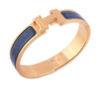 A Clic Clack bangle by Hermes,   the navy enamelled arms to a swivelling H motif clasp, signed