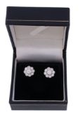 A pair of diamond ear studs,   the flower head clusters set throughout with brilliant cut diamonds,
