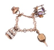 A 9 carat gold charm bracelet  , the fancy links suspending a novelty gem set bird cage, a gem set