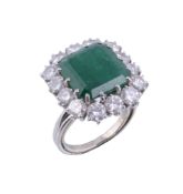 An emerald and diamond cluster ring,   the central square shaped emerald claw set within a surround