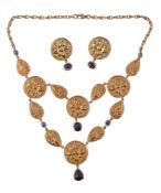 A gold and sapphire necklace,   composed of two rows of circular and pear shaped disks each with
