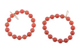 A pair of coral ear hoops,   the circular earrings set with polished coral beads, with shepherd's