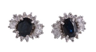 A pair of sapphire and white stone ear studs  , the oval cut sapphires within a surround of step