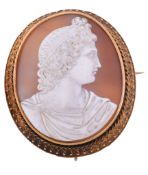 A mid Victorian shell cameo brooch,   circa 1870, carved with the profile of Apollo with his hair