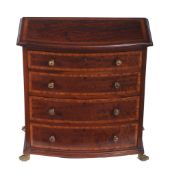 A miniature chest of drawers in George III style  , 19th century, of bowfront outline, on brass