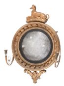 A Regency giltwood wall mirror,   circa 1815, the recumbant dog surmount above circular frame with