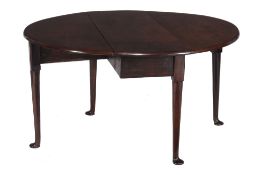 A George III mahogany oval dropleaf table  , circa 1760, the oval top above gateleg action with
