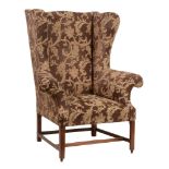 A mahogany wing armchair  , early 19th century, recently reupholstered, with outswept scroll arms