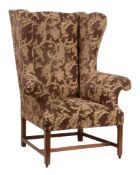 A mahogany wing armchair  , early 19th century, recently reupholstered, with outswept scroll arms