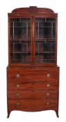 A George IV mahogany secretaire-bookcase  , circa 1825, the break arch cornice above a pair of