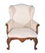 A Continental walnut wing armchair  , mid 19th century, the upholstered back and arms with carved