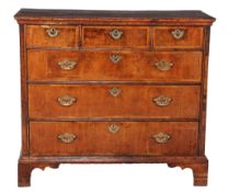 A George II banded walnut chest of drawers  , circa 1735, the top with moulded edge above three