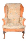 A walnut framed and upholstered wing armchair in George II style,   late 19th /early 20th century,