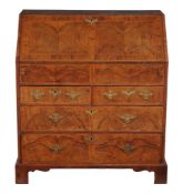 A walnut and feather-banded bureau , circa 1740 and later, the double book matched fall opening to a
