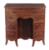 A George III mahogany bowfront kneehole desk  , circa 1790, the arrangement of seven drawers around