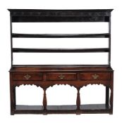 A George III oak dresser,   circa 1770, the three open shelves  with wrought iron cup hooks above