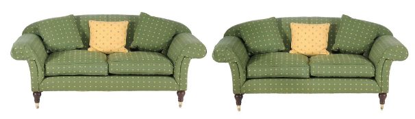 A pair of upholstered Chesterfield sofas  , of recent manufacture, each with over-scrolled arms and